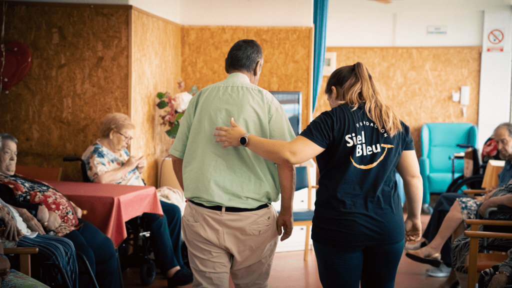Técnica de Siel Bleu acompañando a un hombre mayor durante una sesión de ejercicio físico adaptado en un Centro de Día
