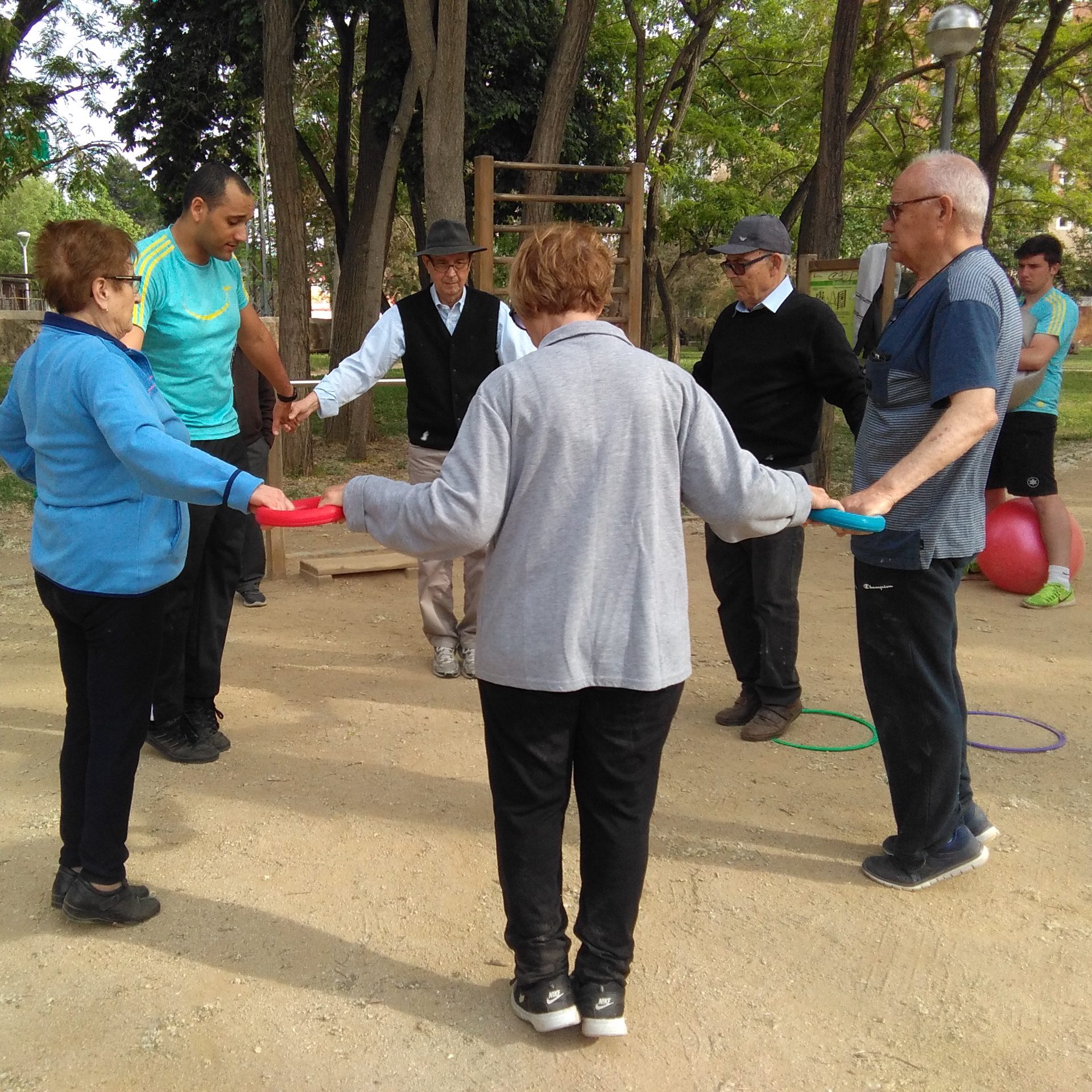 Grupo de personas mayores realizando ejercicios en círculo con apoyo de un entrenador de Siel Bleu
