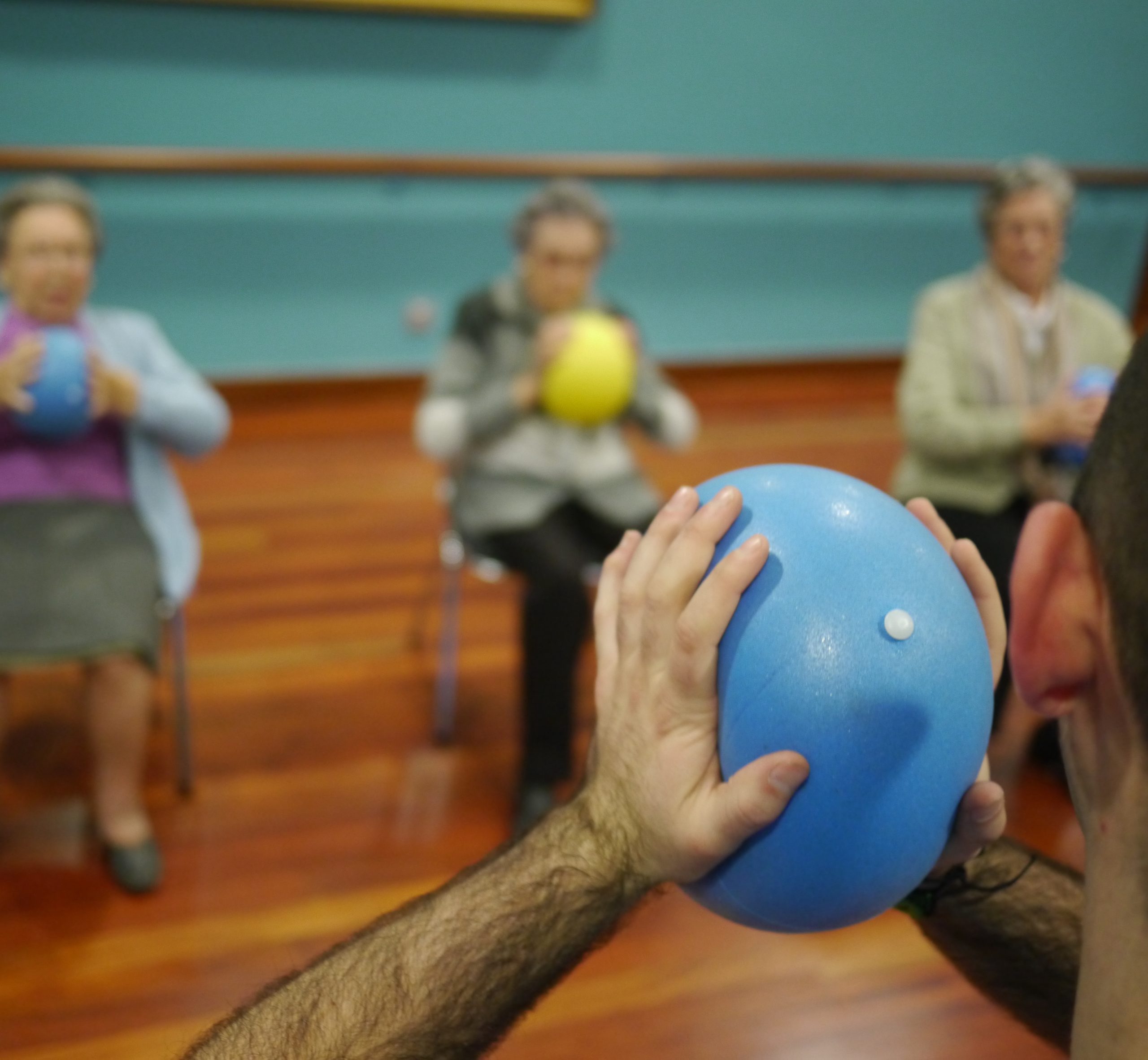 Mujeres mayores asistidas por profesional durante una sesión de ejercicio físico adaptado.