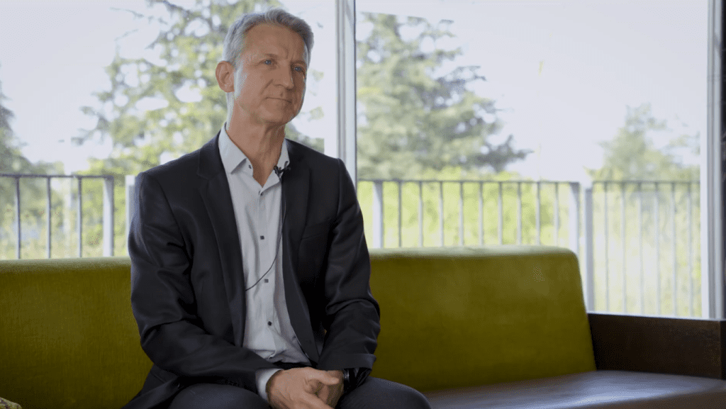 Retrato del Dr. Vincent Cottin, neumólogo experto en enfermedades pulmonares intersticiales, sentado en un sofá durante una entrevista sobre actividad física adaptada para pacientes con fibrosis pulmonar idiopática.