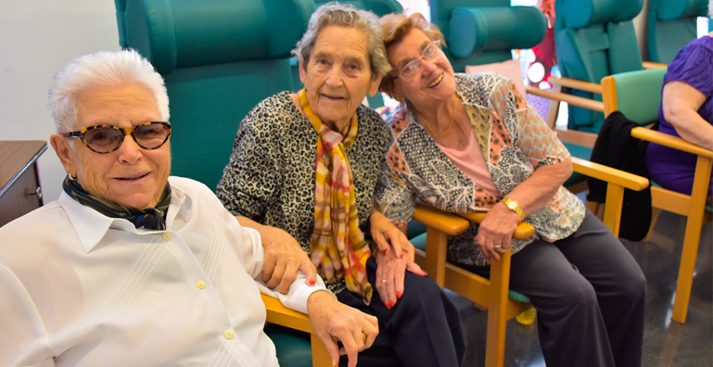 Personas mayores sonrientes sentadas tras una sesión de ejercicio adaptado con Siel Bleu