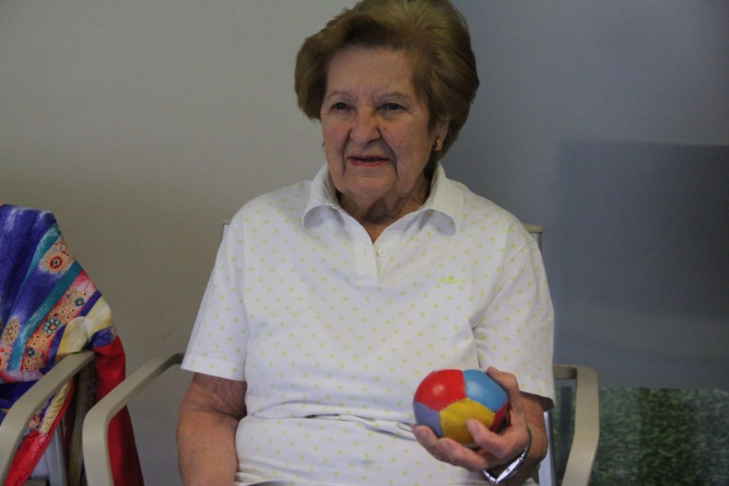 Mujer mayor en sesión de ejercicio físico adaptado con material terapéutico en la Residencia Sagrada Familia de Madrid