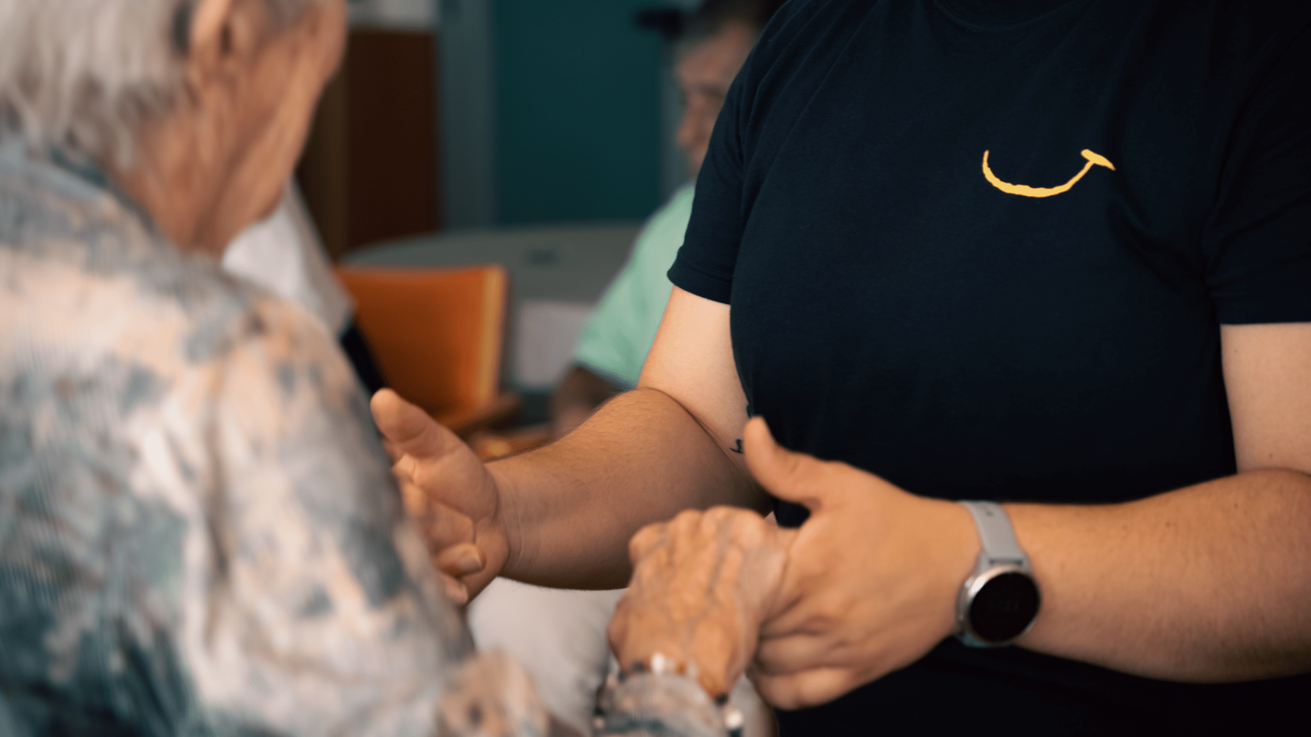 Persona mayor realizando ejercicio físico adaptado con el apoyo de un profesional de Siel Bleu, enfocando la cercanía y el acompañamiento durante una actividad para mayores.