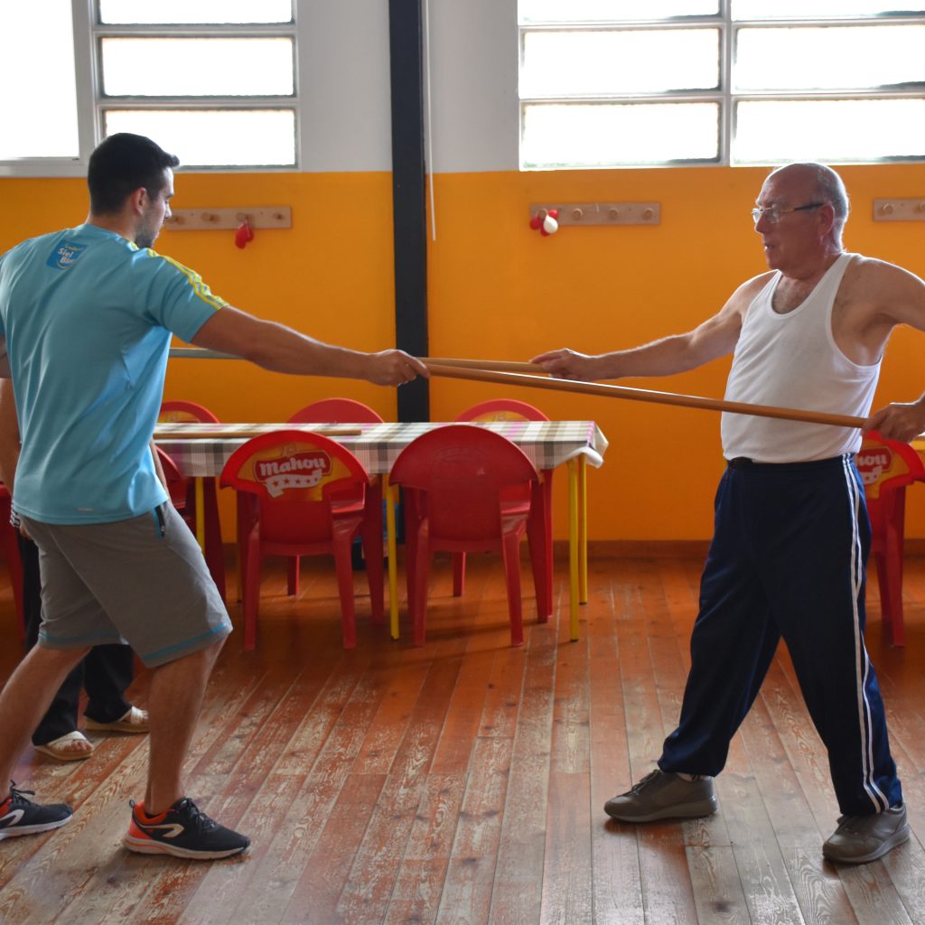 Técnico de Siel Bleu realizando ejercicio funcional con un hombre mayor para mejorar fuerza y prevenir trastornos musculoesqueléticos