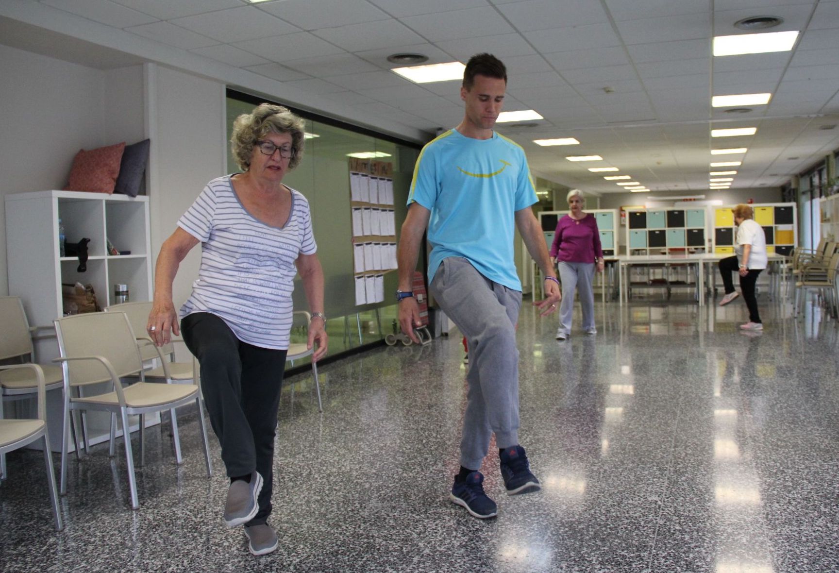 Técnico de Siel Bleu acompañando a una persona mayor durante una sesión de equilibrio.
